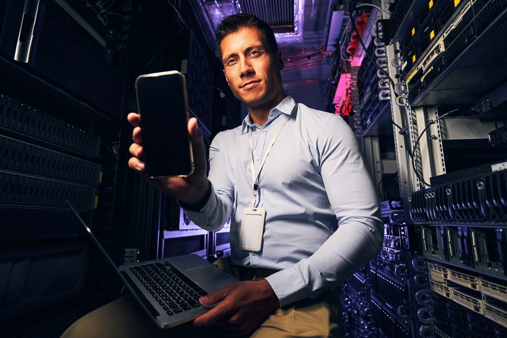 Ingenieur mit Smartphone im Serverraum